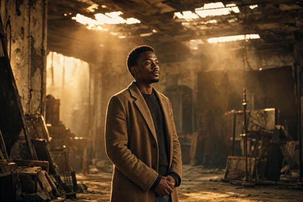 A person is standing in a dim, broken film set with golden light shining through.